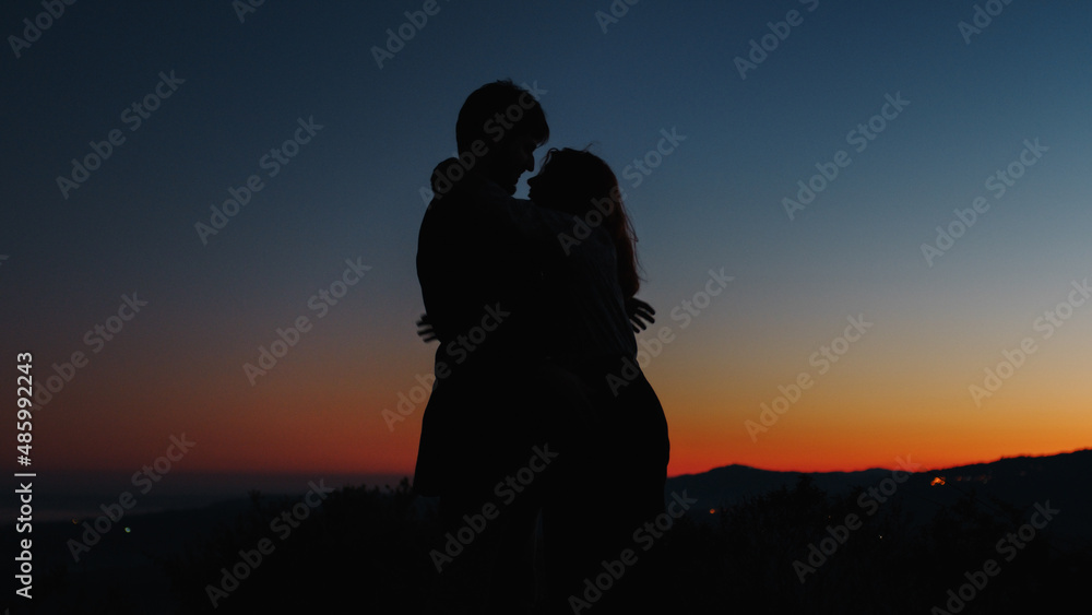 Silhouette of boy and girl hug each other tightly