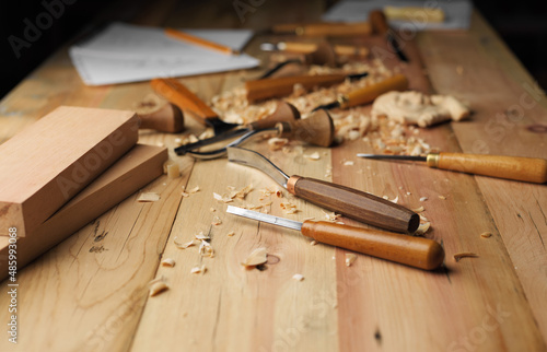 Woodworker's desk with cutters. Woodworking tools and shavings on a wooden table. Wood carving process.