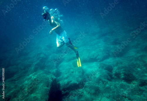 Boy snorkelling with diving flipper undersea