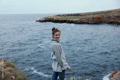 Fototapeta Naklejka Na Ścianę i Meble -  portrait of a woman sweaters cloudy sea admiring nature female relaxing