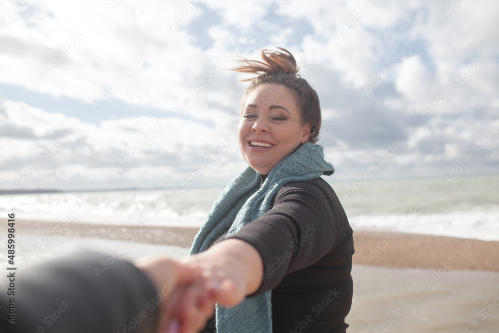 Beatuful woman with over weight body walking in the beach, The plus size model wearing jeans, the warm knitted blanket and sweater. the wind in the bich have fun with hairs Beatuful woman with over weight body walking in the beach, The plus size model wearing jeans, the warm knitted blanket and sweater. the wind in the bich have fun with hairs