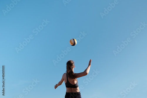 Athlete jumps and kicks a volleyball. Summer sport Beach volleyball.