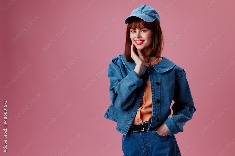 Positive young woman denim clothing fashion posing cap color background unaltered Positive young woman denim clothing fashion posing cap color background unaltered