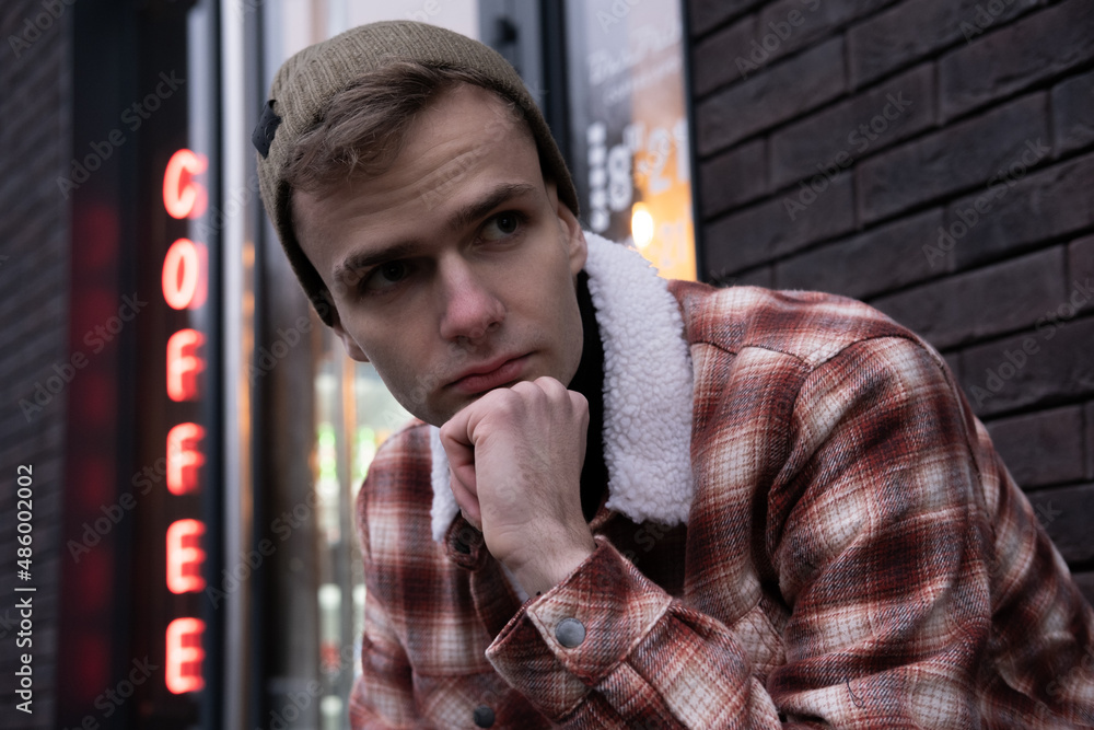 street portrait of a pensive guy next to a coffee shop