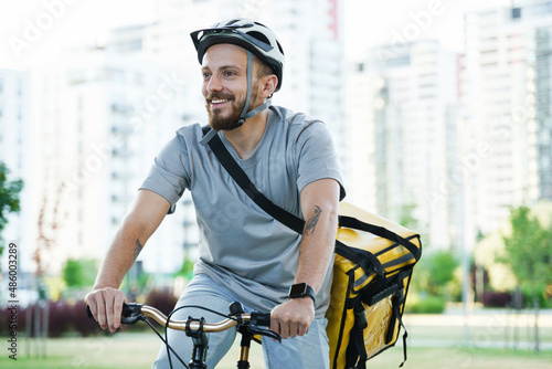 Express delivery courier riding bicycle with insulated bag.