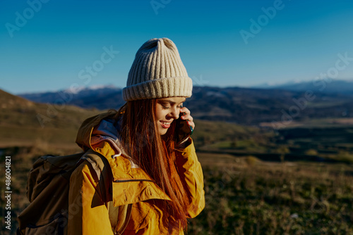 woman tourist in a yellow jacket in a hat backpack travel mountains Fresh air