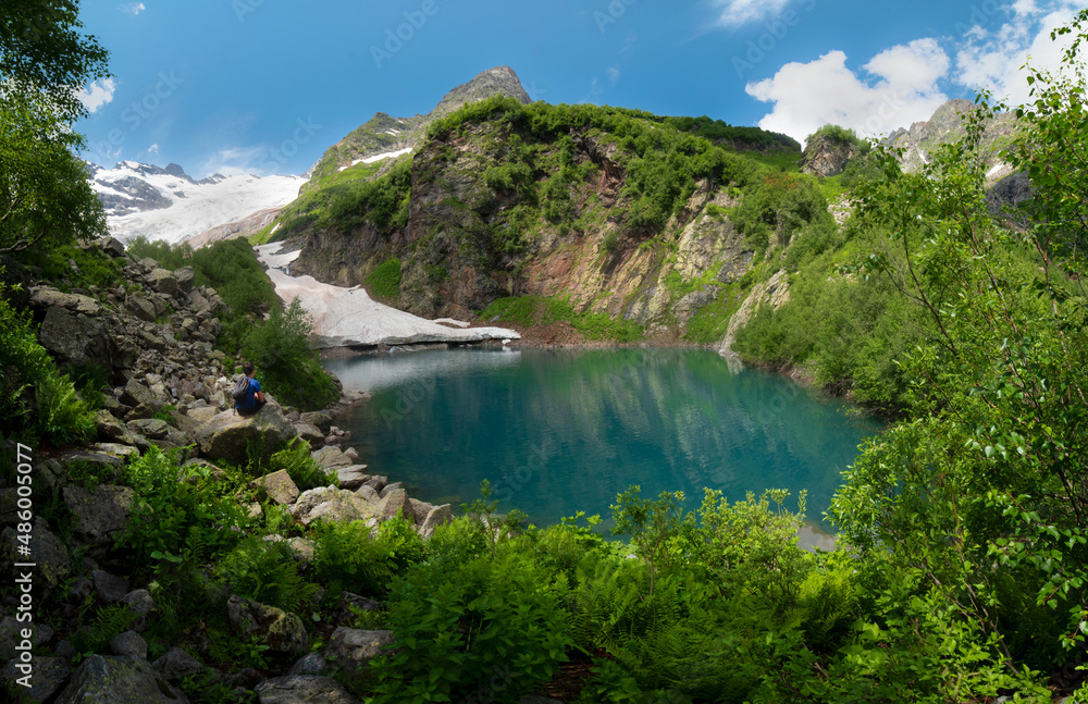 Mountain Lake Turye surrounded by green plants in the Dombai Mountains.