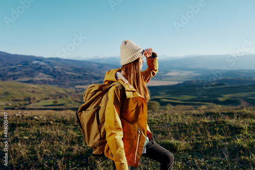 woman traveler in a yellow jacket in a hat backpack travel mountains Lifestyle