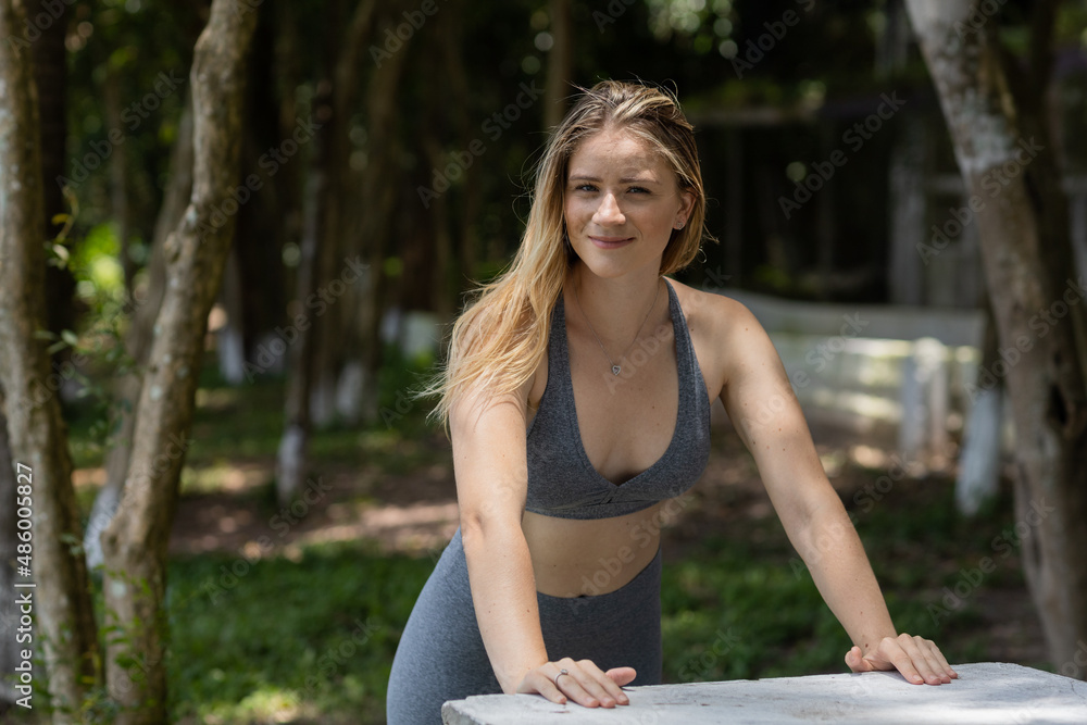 Happy oung woman exercising at a park on a beautiful sunny day. Woman working out. Green and nature background. Happy oung woman exercising at a park on a beautiful sunny day. Woman working out. Green and nature background.