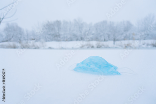 medical mask lies on white snow