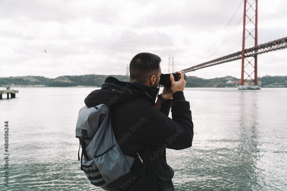 Obraz premium Photographer taking pictures of the bridge 25 April in Lisbon, Portugal