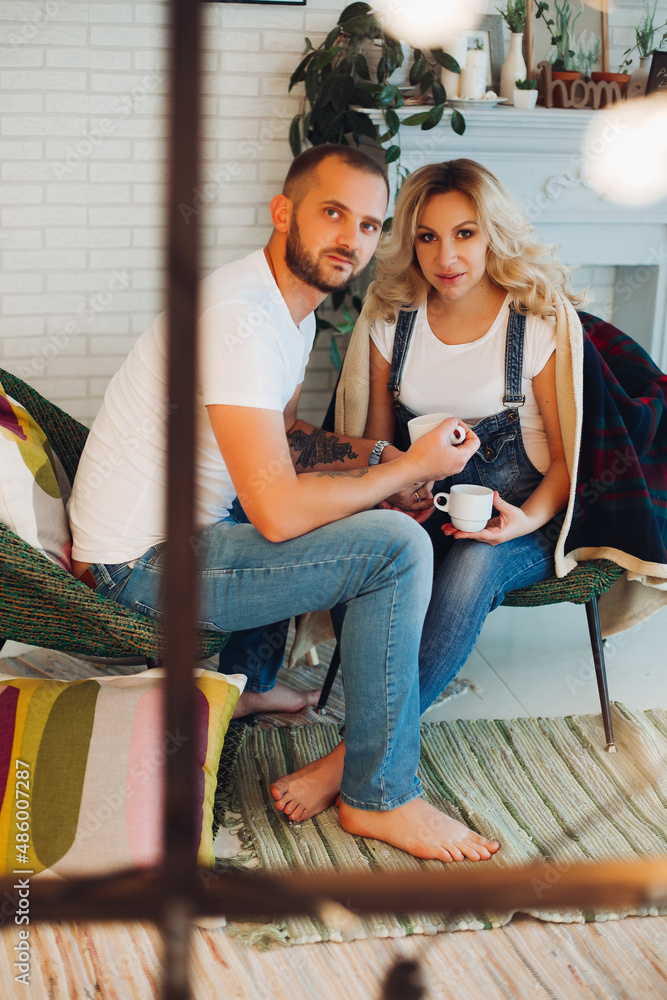 Obraz premium Stylish couple sitting on bad and embracing stomach.