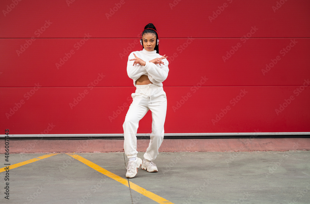Cheerful African American girl with long black hair dressed in sportswear listening to music Cheerful African American girl with long black hair dressed in sportswear listening to music