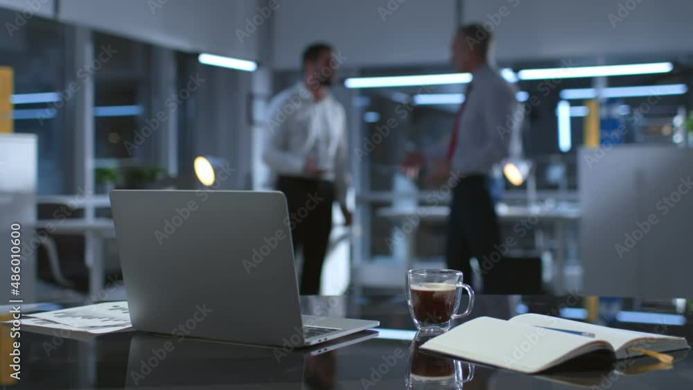 Blurred shot of business partners having argument late in office Blurred shot of business partners having argument late in office