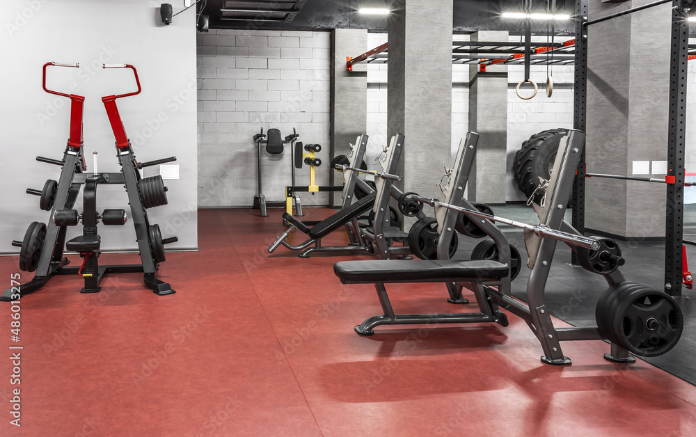 Various powerlifting equipment in spacious, well lit, empty gym interior. Special modern exercise machines for physical training. Sport, fitness