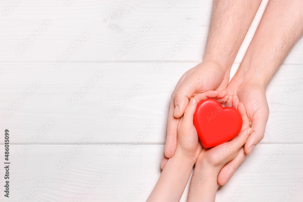 Man give red heart to kid as couple. Healthcare and hospital medical concept. Donation concept.Symbolic of Valentine day.Top view with space for text. Man give red heart to kid as couple. Healthcare and hospital medical concept. Donation concept.Symbolic of Valentine day.Top view with space for text.