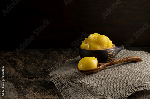 Pure or melted ghee. Diet concept with healthy fats. On a dark wooden table. Old rustic style. photo