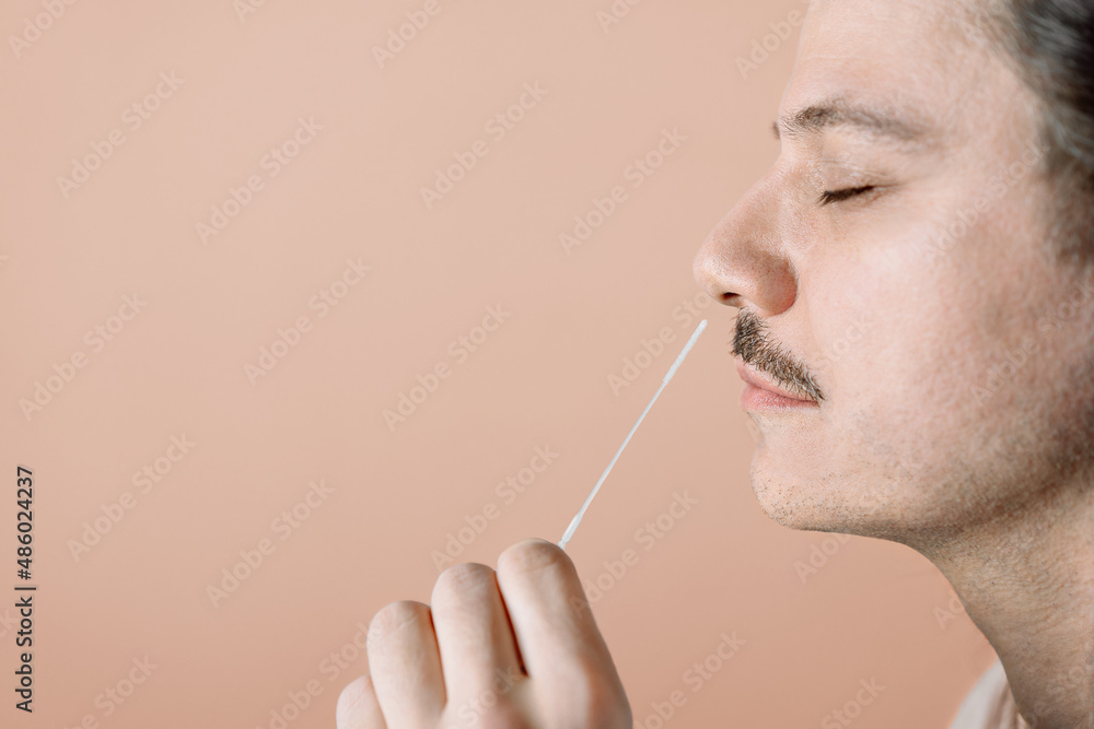 Obraz premium Man using nasal swab for Covid-19 antigen test