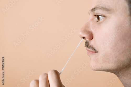 Man using nasal swab for Covid-19 testing