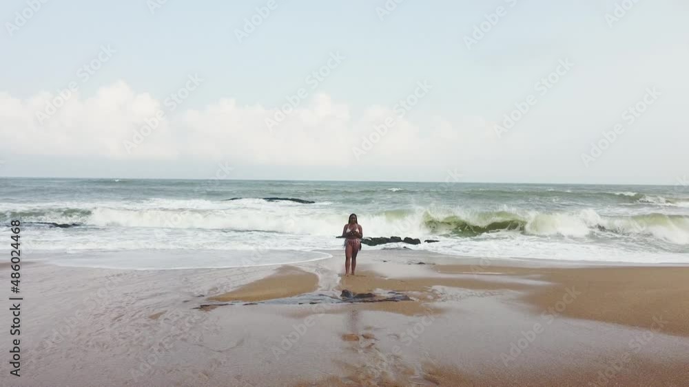 Woman with drone remote control on sandy beach, Elmina, Ghana Woman with drone remote control on sandy beach, Elmina, Ghana