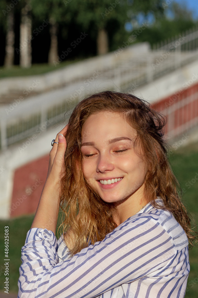 Portrait of happy smiling caucasian young woman with closed eyes