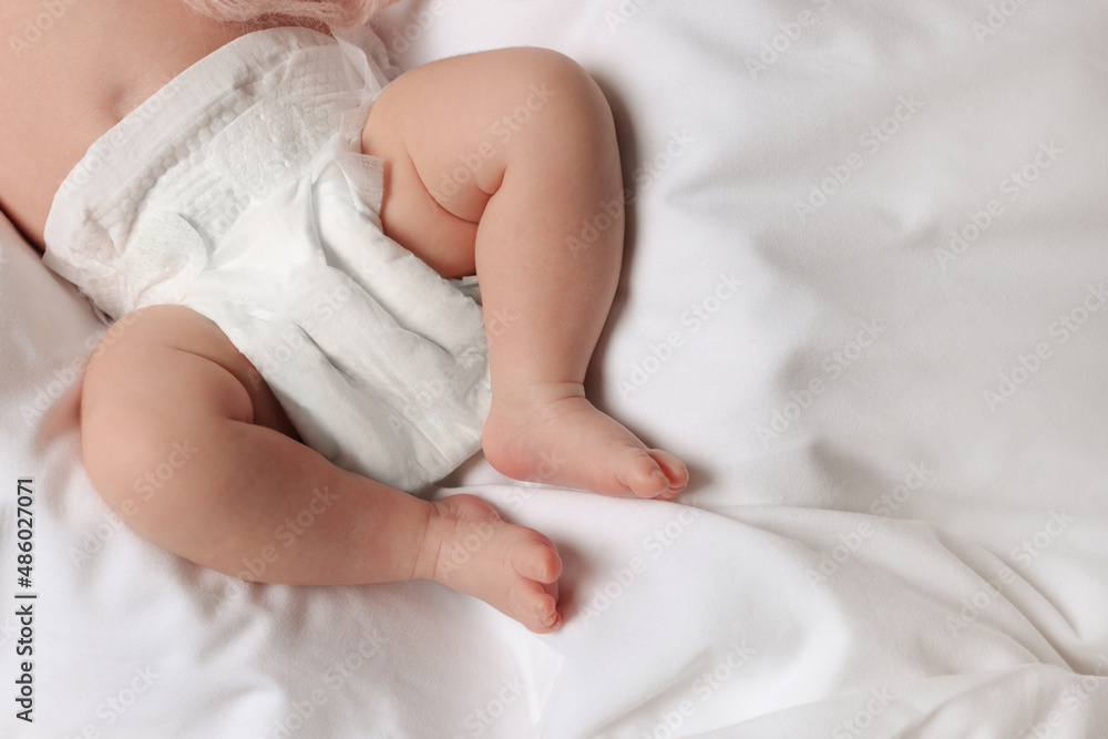 Little baby in diaper lying on soft bed, top view. Space for text Little baby in diaper lying on soft bed, top view. Space for text