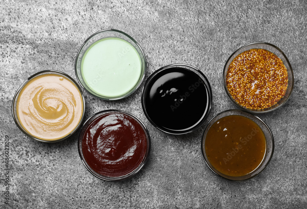 Many different sauces on grey table, flat lay Many different sauces on grey table, flat lay