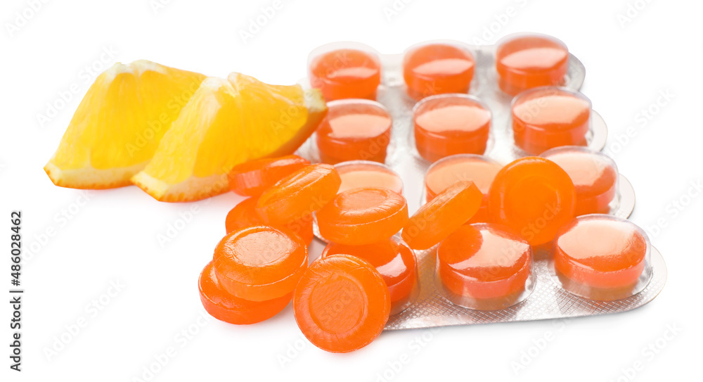 Many cough drops and orange on white background