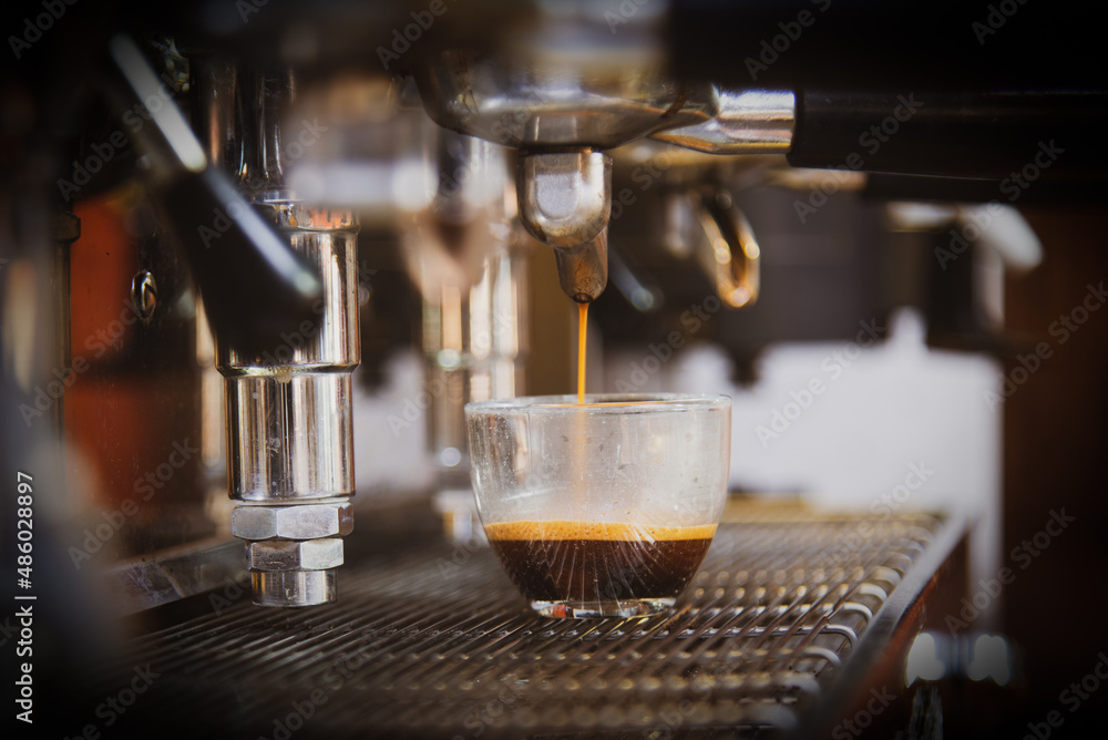 Close-up of espresso pouring from the coffee machine. Professional coffee preparation