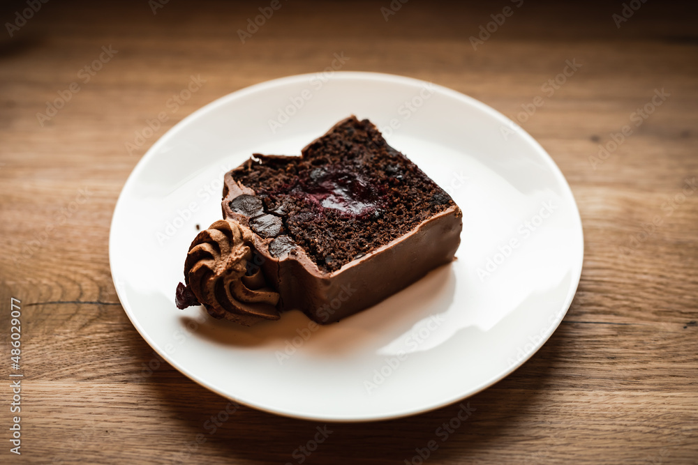 A chocolate cake with cherry filling served on a plate, selective focus natural light image A chocolate cake with cherry filling served on a plate, selective focus natural light image