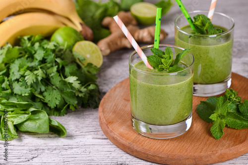 Fresh organic detox green drink smoothie with celery, spinach, banana, cilantro, lime and ginger with refreshing mint. Healthy, dietary, vegetarian food