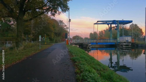 Pov hyperlapse or timelapse over a river with the rising sun and an idyllic scenery and a draw bridge. High quality 4k footage photo