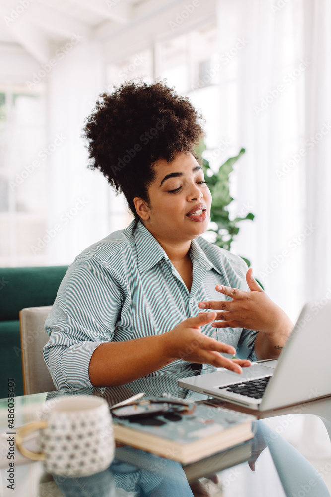 Woman at home video conferencing on laptop