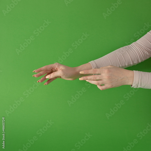 women hands against green background. modern minimalism with copyspace