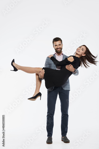 Bearded man holding beautiful girlfriend in arms