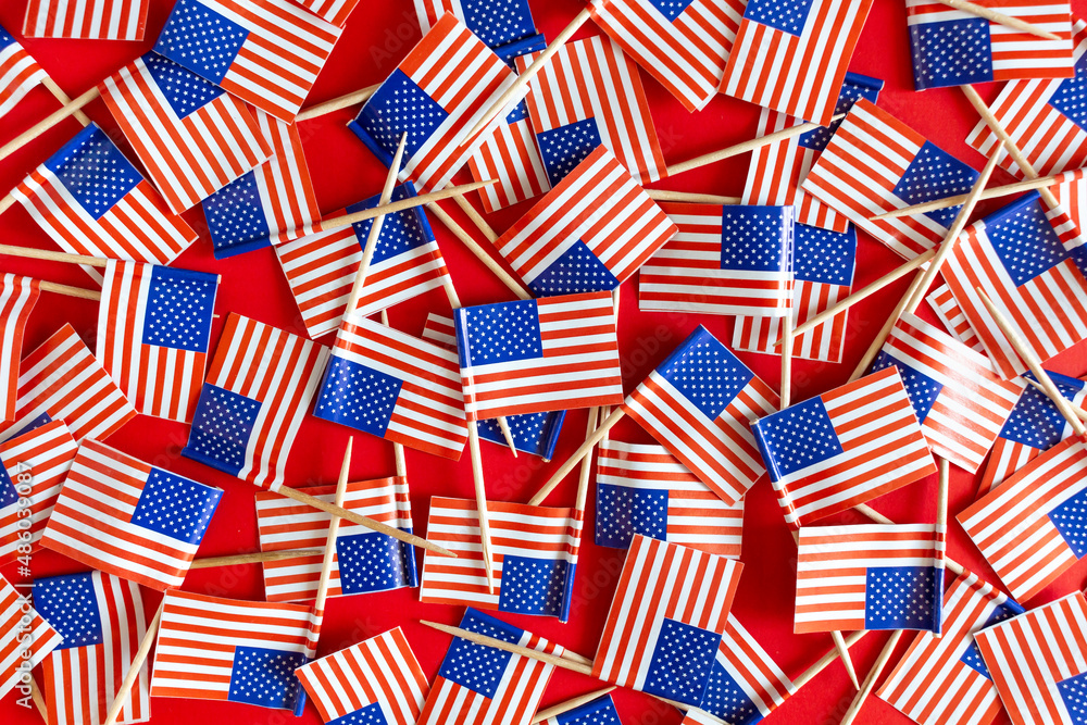 Fototapeta premium American flags flat lay on the red background. USA national day USA celebration.