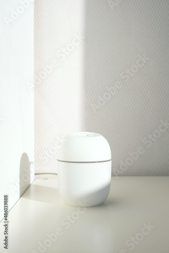 Wallpaper Mural The humidifier is powered by USB on a white background with bright sunlight. Mini diffuser on  white background.  Torontodigital.ca