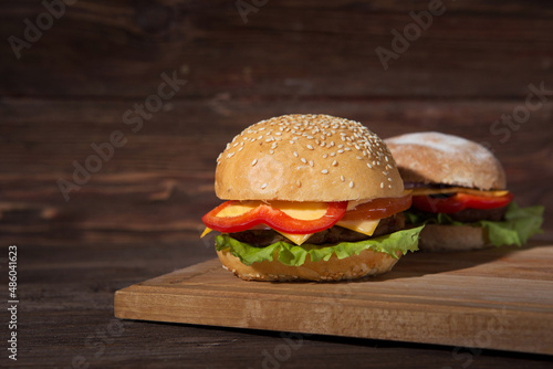 Hamburger on wood board over rustic background