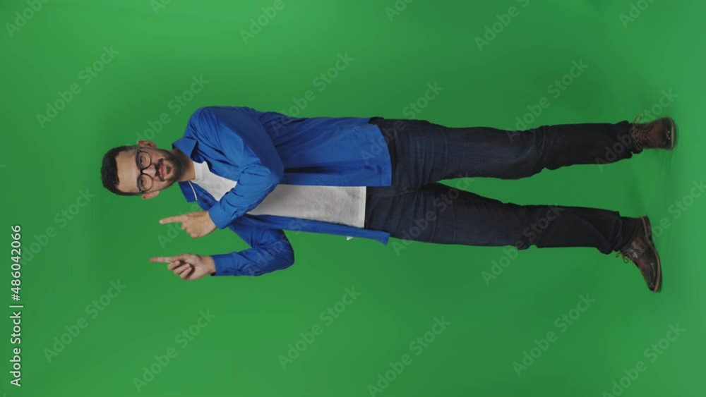 Surprised caucasian man pointing with two hands and fingers to the side. Happy person showing things at indoor studio shot isolated on green background. Vertical video Surprised caucasian man pointing with two hands and fingers to the side. Happy person showing things at indoor studio shot isolated on green background. Vertical video