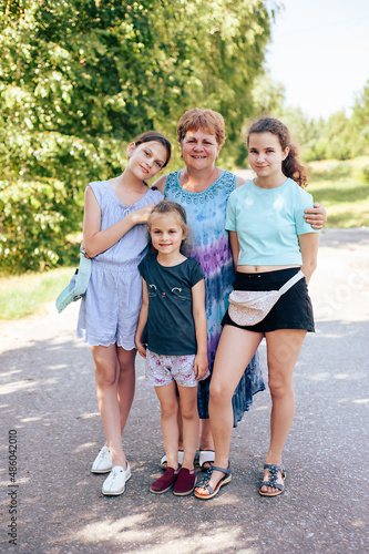 Grandmother and her three granddaughters in the park in summer