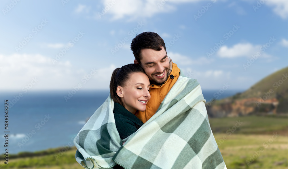 Φωτογραφία love, travel and tourism concept - happy smiling couple in warm blanket over big