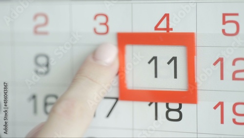 Close-up of a woman's finger moves the date pointer on the calendar