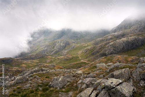 The cloud covered rocky mountain summits of Broad Crag and Scafell Pike from Lingmell Col in the English Lake District, UK.