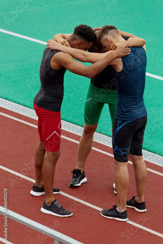 Sportsmen hug each other before run on treadmill