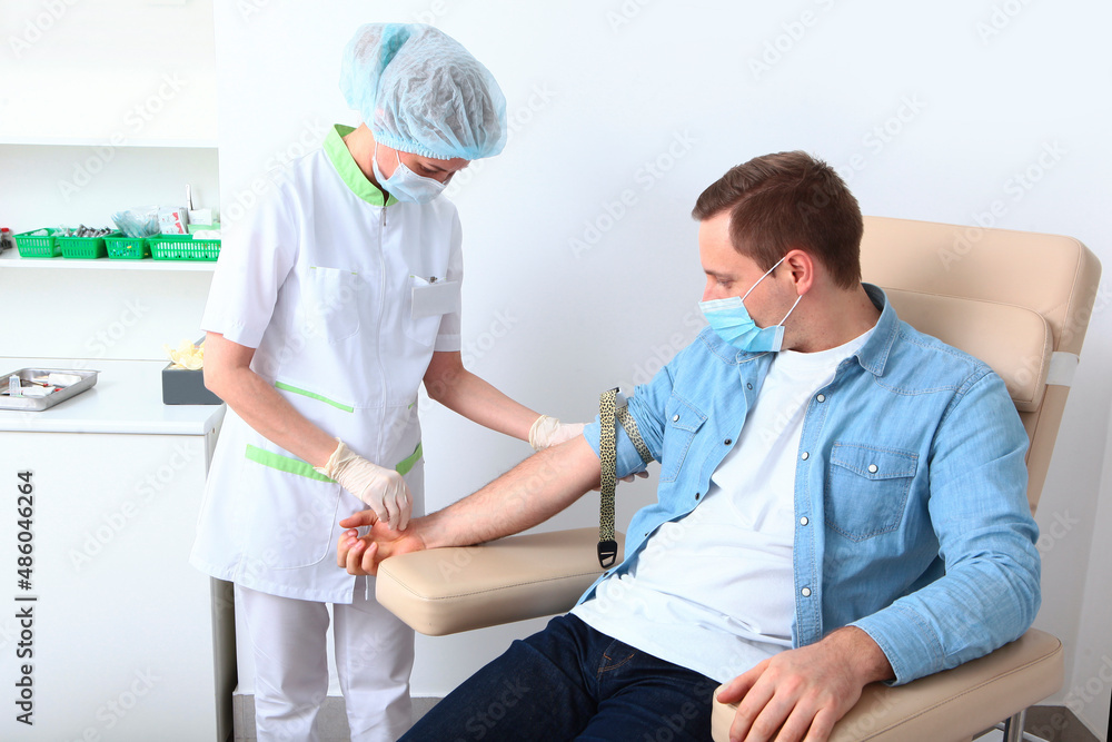 A man donates blood in a medical laboratory. Tourniquet on the patient's arm. A general blood test. Nurse and patient. The concept of healthcare.Copy space. A man donates blood in a medical laboratory. Tourniquet on the patient's arm. A general blood test. Nurse and patient. The concept of healthcare.Copy space.