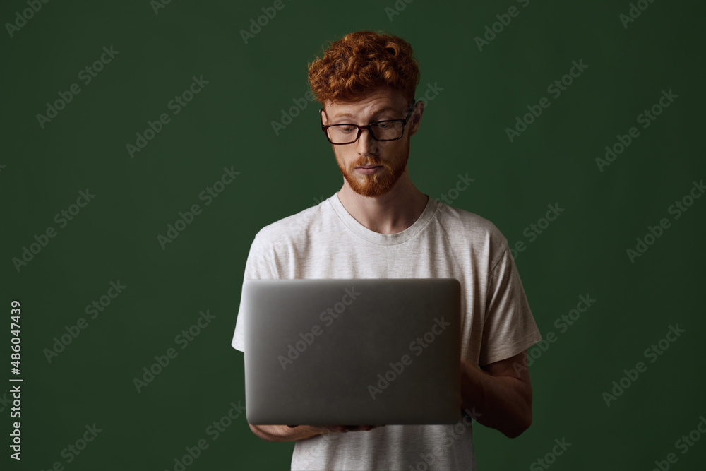 Surprised red hair guy watch something on laptop Surprised red hair guy watch something on laptop
