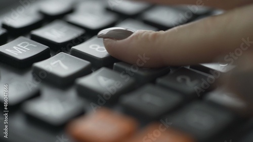 Close-up of a woman's hand using a calculator