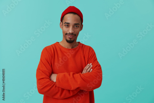 Black guy posing on turquoise background in studio