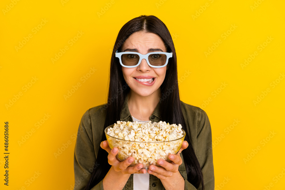 Photo of sad young lady watch movie hold pop-corn wear khaki shirt eyewear isolated on yellow background