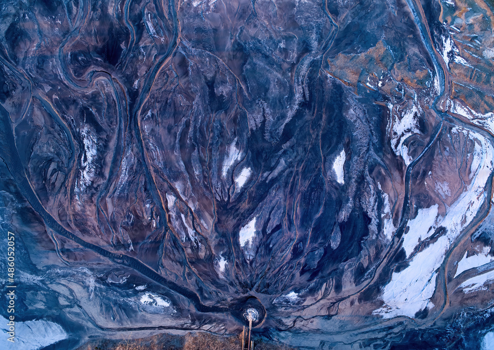 Abstraction. Water erosion in winter. Aerial view of river delta and ice. Shades of blue and orange. Natural abstract background. Water-shaped shapes, illuminated by the sun. Abstraction. Water erosion in winter. Aerial view of river delta and ice. Shades of blue and orange. Natural abstract background. Water-shaped shapes, illuminated by the sun.